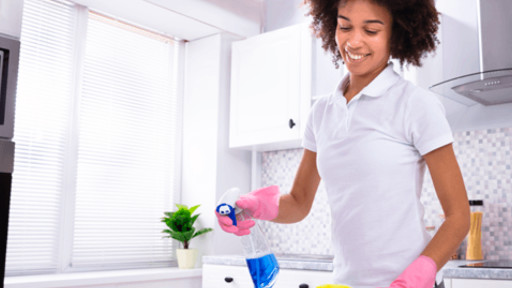 Person spraying down a surface to disinfect it